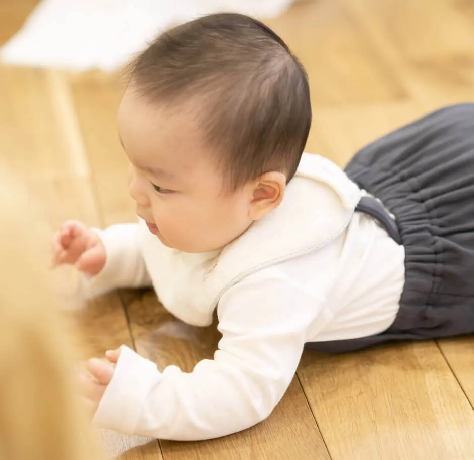赤子が木の床に寝そべっている様子